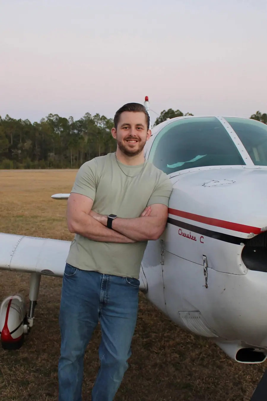 Trayson Glenn standing beside the training aircraft